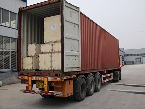 Several wooden cases of SMC water tanks in the container.